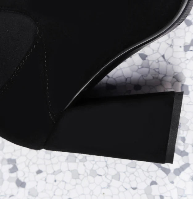Close-up of a black shoe with a textured gray surface