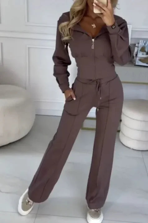 Person wearing a brown tracksuit in a room with light-colored walls and flooring.