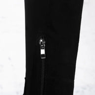 Close-up of a black jacket with a zipper and brand logo on a white background