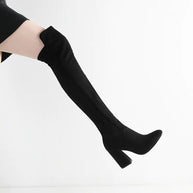 Black knee-high boots worn by a person on a white background