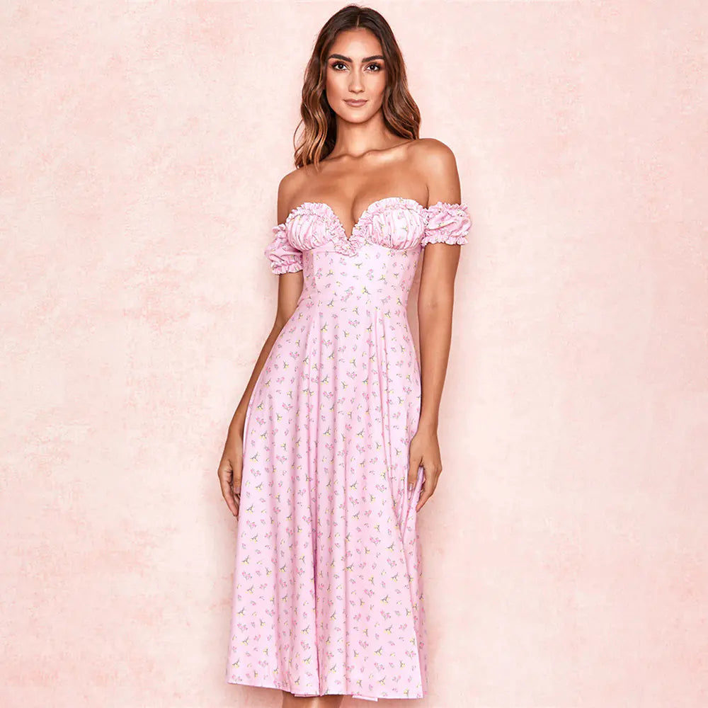 Woman wearing a pink off-shoulder dress with floral details on a pink background