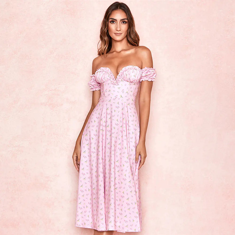 Woman wearing a pink off-shoulder dress with floral details on a pink background