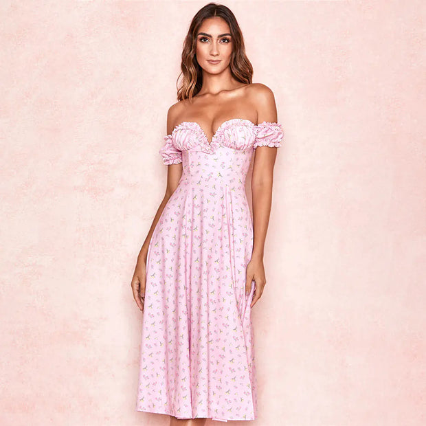 Woman wearing a pink off-shoulder dress with floral details on a pink background