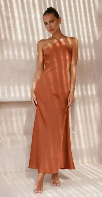 Woman wearing a rust-colored dress against a neutral background
