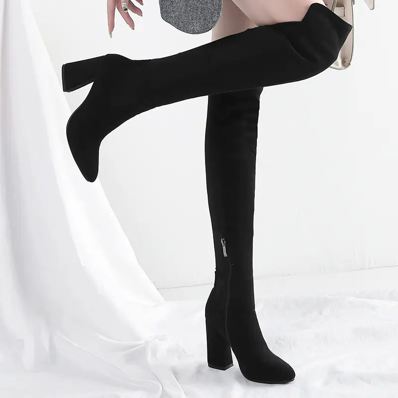 Black over-the-knee boots with a zipper on a white background