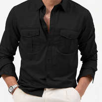 Black button-up shirt with rolled-up sleeves worn by a person on a white background