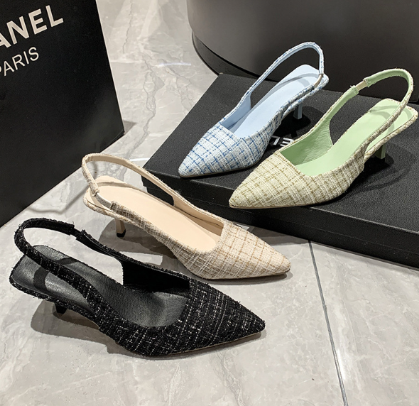 Four pairs of women's slingback shoes in different colors on a marble surface with a Chanel logo in the background.
