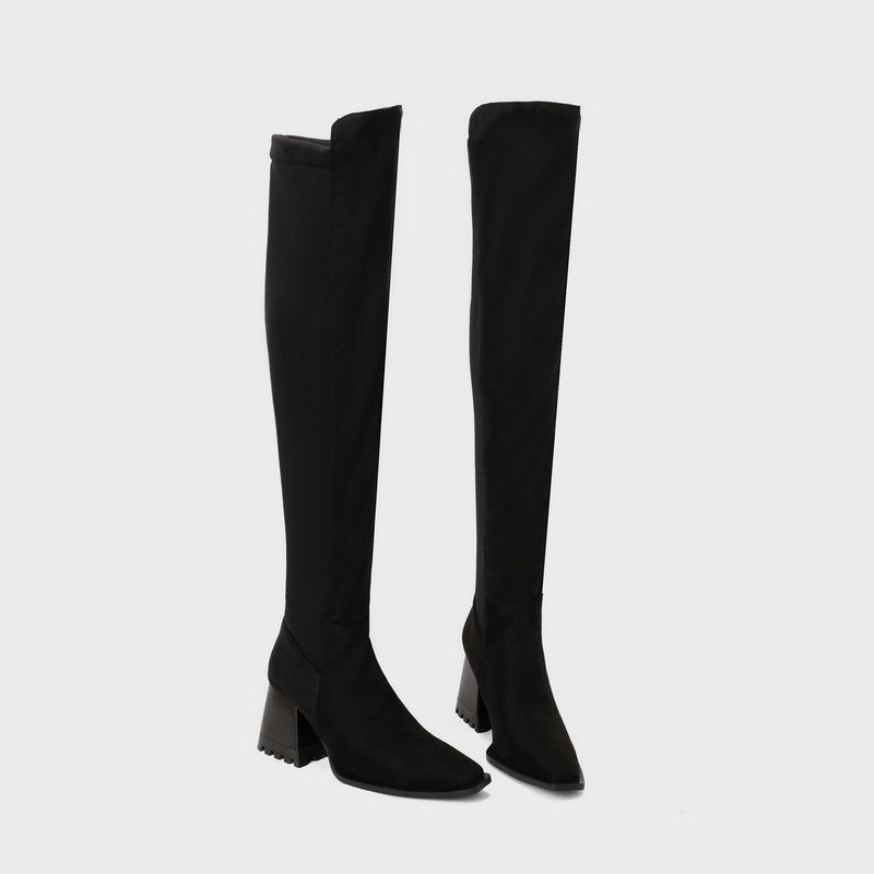 Black knee-high boots on a light gray background