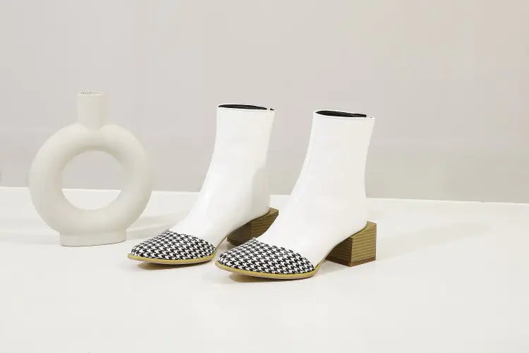 White ankle boots with black and white checkered shoes on a light gray background