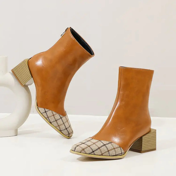 Pair of brown ankle boots with patterned toes on a white background