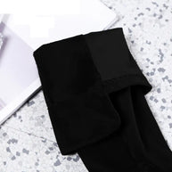 Folded black fabric on a textured white surface