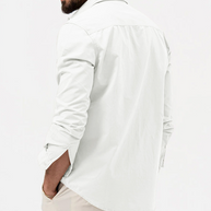 Person wearing a white long-sleeve shirt on a plain background